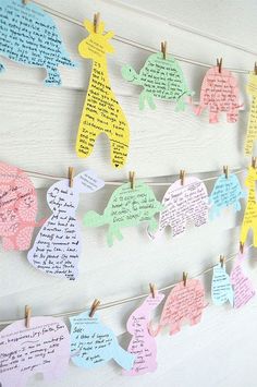 paper elephants are hung on clothes pins with handwritten notes attached to the pegs