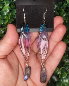 Introducing these enchanting Fairy Wing Earrings, a whimsical addition to your jewelry collection. These ethereal earrings feature cool-toned resin fairy wing charms, along with the inclusion of real quartz adds a touch of natural beauty. Measuring at 3 inches long, these Fairy Wing Earrings are designed to catch the eye and inspire awe. Whether you're embracing the enchantment of fairycore or the cozy charm of cottagecore aesthetics, these earrings are the perfect accessory to complete your look. From dreamy tea parties to mystical forest adventures, these earrings effortlessly elevate your outfit to fairy-tale heights 🧚🏻   The sterling silver earring hooks not only add a touch of elegance, but they are also perfect for those with sensitive ears, ensuring comfort throughout the day. Ethereal Earrings, Fairycore Earrings, Earrings Fairycore, Fairy Wing Earrings, Earrings Cottagecore, Fairy Tale Jewelry, Cottagecore Jewelry, Fairy Earrings, Fairy Wings