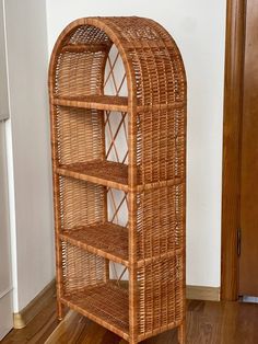 a wicker book shelf sitting on top of a hard wood floor