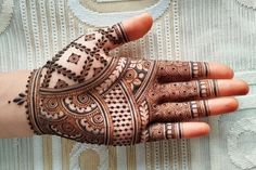 a woman's hand with henna tattoos on it