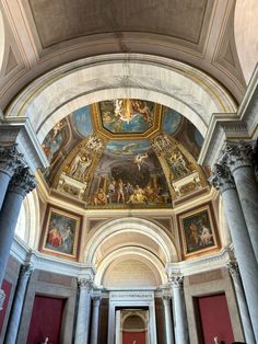 the inside of a building with many paintings on the ceiling and columns in front of it