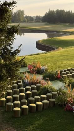 an outdoor seating area in the middle of a grassy field with flowers and trees around it