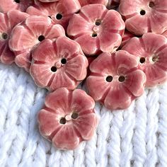 some pink flowers are laying on a white blanket