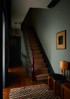 a stair case next to a wooden table and chair in a room with blue walls