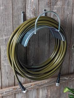 a garden hose hanging on the side of a wooden fence