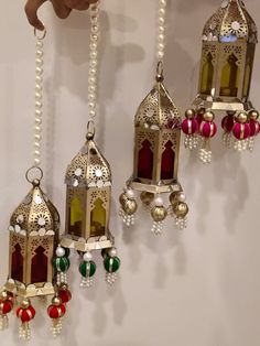 several hanging ornaments with beads and bells attached to the side of a wall in a room