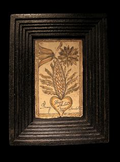 a painting with flowers and leaves on it in a black frame against a dark background