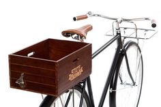 a bicycle with a wooden crate attached to the front wheel and handlebars, against a white background