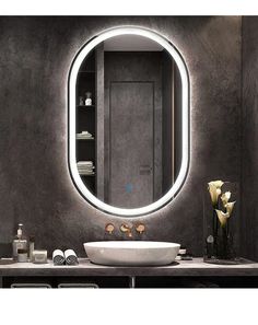 a bathroom sink sitting under a round mirror