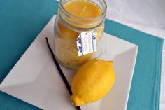 a lemon sitting on top of a white plate next to a mason jar filled with liquid