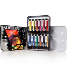 an assortment of art supplies including markers and pens in a tin on a white background