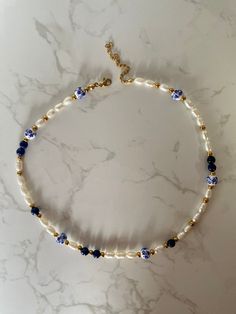 This pearl necklace screams summer to me, with waterproof and tarnish-resistant gold beads, blue flower-printed porcelain ceramic beads, and stunning lapis lazuli. Wear this natural gemstone pearl necklace alone, or stacked with your favourite necklaces, falling at 16 inches, it sits around your neck/ above your collar bone.  The extenders, clasps and beads are all PVD coated, which means you need not fear this necklace tarnishing after a dip in the pool. Lapis Lazuli is a wonderful healing ston Pearl And Beaded Necklace, Glass Bead Color Combos, Bead Necklace Stack, Beaded Necklace With Letters, Ceramic Bead Necklace, Elegant Beaded Jewelry, Pearl Beads Bracelet, Porcelain Jewelry Handmade, Tous Necklace