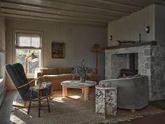 a living room filled with furniture and a fire place next to a stone wall fireplace