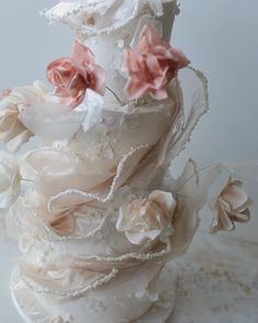 a wedding cake decorated with flowers and pearls