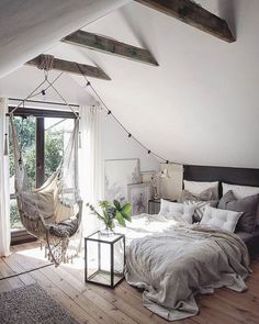 a bedroom with a hammock hanging from the ceiling and bed in front of it