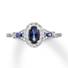 an oval shaped ring with two blue sapphires and diamonds on the sides, set in white gold