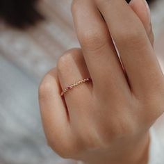 a woman's hand with a gold ring on her finger and a diamond in the middle