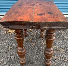 an old wooden table sitting on top of gravel