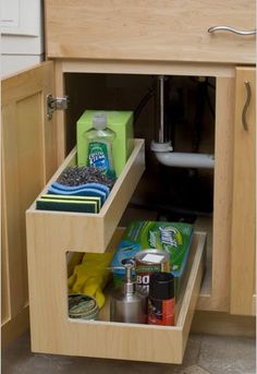 an open drawer in a kitchen filled with cleaning products