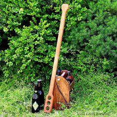 a wooden utensil and bottle holder in the grass