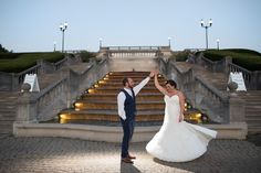 a bride and groom dancing in front of stairs