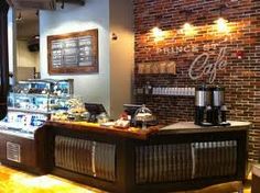 the inside of a coffee shop with brick walls