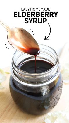 homemade elderberry syrup in a glass jar with a spoon