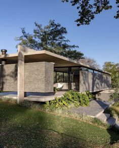 a concrete structure with plants growing out of it's sides in front of a house