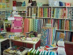 a room filled with lots of different colored fabrics