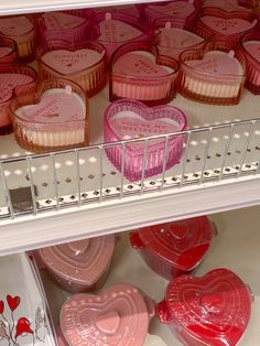 pink and red heart shaped cupcakes on display in a store shelf with other valentine's day treats