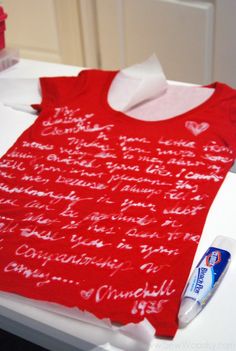 a red t - shirt with writing on it sitting on top of a white counter