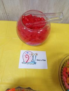 a bowl filled with jelly beans next to a sign that says party's fish