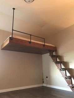 a loft bed with stairs in the middle and a ladder above it to go up