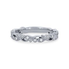 a white gold wedding band with diamonds on the sides and an intricate vine design in the middle