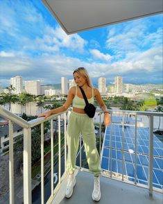 a woman standing on a balcony with solar panels in the background