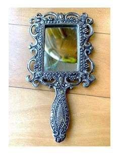 an ornate mirror hanging on the side of a wooden wall next to a wood floor