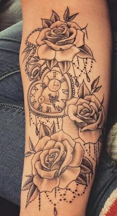 a woman's leg with tattoos on it and roses in the middle of her legs