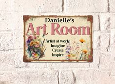 a sign on the side of a white brick wall that says, art room artist at work imagine creative inspire