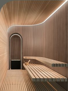 a wooden room with two benches and a door leading to another area that has wood slats on the walls