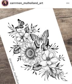 a black and white drawing of flowers with butterflies on it, next to a wooden table