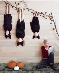 three people are hanging upside down on the wall