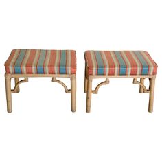 a pair of stools made out of bamboo with striped cushions on each one side