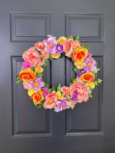 a wreath with flowers is hanging on the front door to decorate it for someone's special occasion