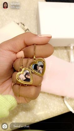 a woman holding two heart shaped pendants in her hand