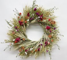 a wreath made out of dried flowers and grass