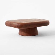 a wooden object sitting on top of a white surface