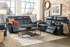 a living room with two recliners and a coffee table in front of a brick wall