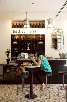 a woman sitting at a table in front of a counter