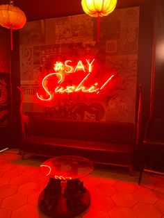 a red neon sign that says say sushi in front of a glass table with shoes on it