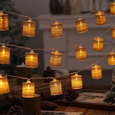 mason jar lights are strung from rope and hung on a tree branch with pine cones in the background